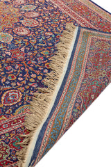 Detalle de la esquina plegada de una alfombra persa, mostrando el reverso y los colores vibrantes del diseño.