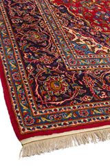 Vista en perspectiva de una alfombra persa, mostrando la riqueza del diseño con un medallón central y bordes decorativos.
