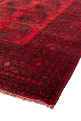 Vista en ángulo de la alfombra oriental roja mostrando la textura y los detalles.