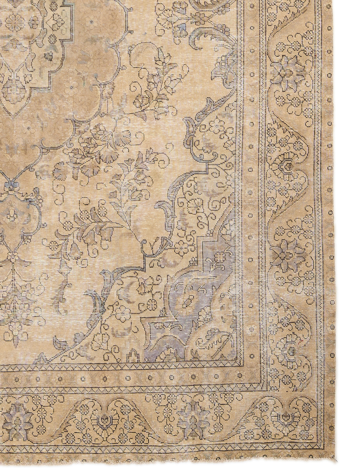 Detalle de la alfombra con su esquina ligeramente doblada, mostrando el reverso y los patrones ornamentales.