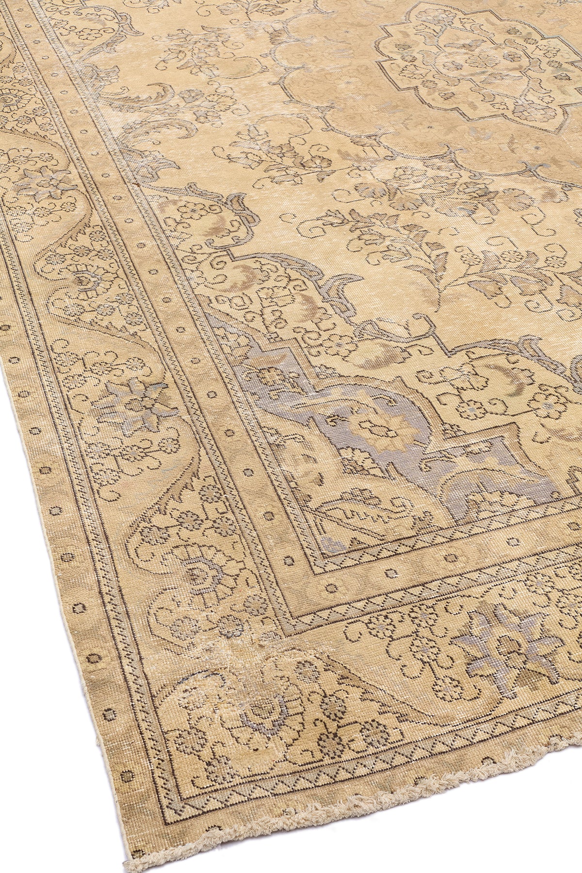 Vista completa de una alfombra beige con un diseño central floral y un borde decorado con motivos clásicos en tonos neutros.