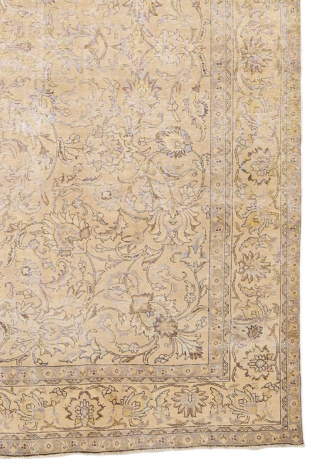 Detalle del borde inferior derecho de la alfombra mostrando el diseño floral en tonos neutros y contorno envejecido.