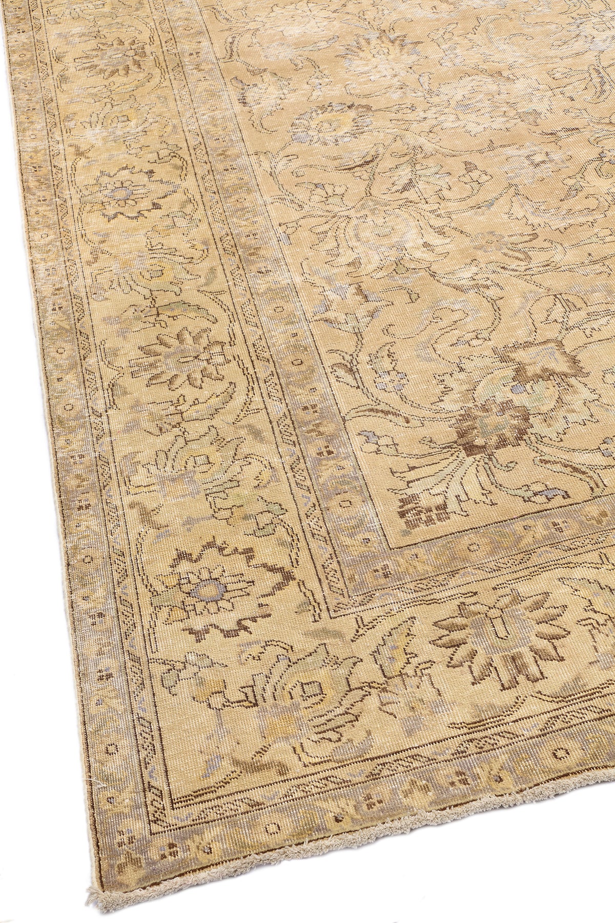 Esquina inferior izquierda de la alfombra con motivos florales bien definidos y detalles de desgaste natural.