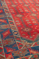 Vista lateral de la alfombra roja, destacando el intrincado patrón geométrico que cubre toda su superficie.
