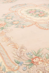 Vista de ángulo bajo de una alfombra floral beige, mostrando los detalles de flores intrincadas y bordes suaves