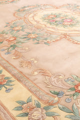Diseño de alfombra floral beige con acentos verdes y rosas, borde detallado con motivos florales y volutas