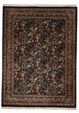 Alfombra de fondo negro con intrincados detalles florales en tonos rojos, verdes y dorados.