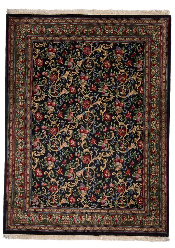 Alfombra de fondo negro con intrincados detalles florales en tonos rojos, verdes y dorados.