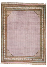 Alfombra tradicional con diseño central en tonos rosa pálido y detalles geométricos en el borde.