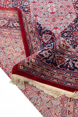 Parte trasera de alfombra oriental mostrando la estructura tejida y el borde decorativo con flecos.
