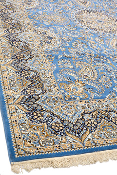 Vista lateral de alfombra persa azul mostrando patrones florales simétricos y borde decorativo detallado en tonos claros.