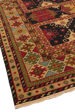 Vista lateral de una alfombra oriental resaltando su borde con detalles florales y geométricos en tonos beige y rojo.