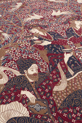 Vista de cerca de la decoración floral y figuras humanas en una alfombra tradicional.