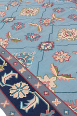 Parte inferior de la alfombra azul con flecos y bordes decorativos en tonos oscuros y claros.