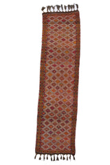 Alfombra kilim tradicional con fondo burdeos y diseño geométrico.