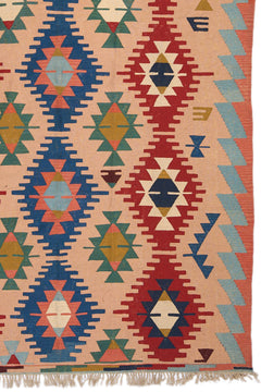Detalle del patrón geométrico central en azul y rojo de la alfombra, con diseños de rombos en colores vivos.
