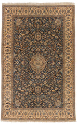 Vista completa de una alfombra oriental con un diseño central en tonos beige y azul.