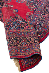  Detalle del centro de la alfombra con su medallón floral rodeado por patrones geométricos y florales en colores vibrantes.