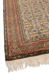 Alfombra de diseño persa clásico con patrones simétricos y colores cálidos predominantes.