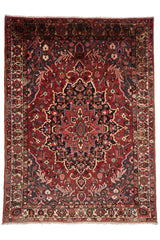 Alfombra beige con borde rojo decorada con patrones florales intrincados.