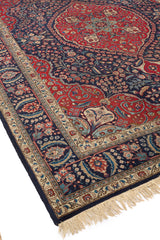 Alfombra oriental con diseño hexagonal rojo y azul oscuro, bordeada con detalles geométricos complejos.