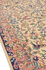 Primer plano de la alfombra mostrando patrones detallados de flores con una franja decorativa rosa y azul.