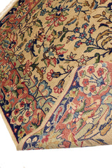 Detalle de la alfombra doblada que revela el reverso, mostrando su calidad artesanal y los patrones florales en colores vibrantes.
