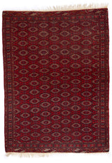 Vista completa de una alfombra roja con patrones geométricos tradicionales y borde detallado.