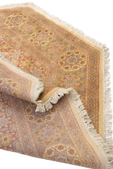 Alfombra oriental doblada para mostrar la textura y los detalles de los patrones geométricos multicolores.