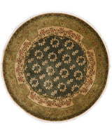 Alfombra circular verde oscuro con detalles florales.