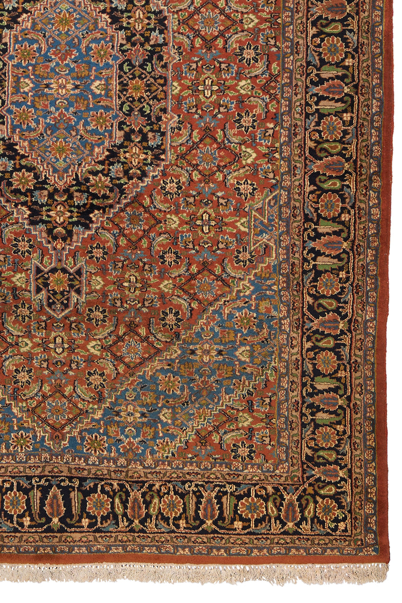 Detalle del borde derecho de la alfombra persa mostrando motivos florales sobre un fondo negro con intrincado trabajo artesanal.