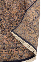 Detalle de la esquina doblada de la alfombra, mostrando la calidad del tejido y el reverso de la pieza con flecos de algodón natural.