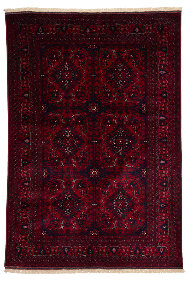 Vista completa de la alfombra oriental con fondo rojo intenso y patrones simétricos florales en tonos rosado, blanco y negro.