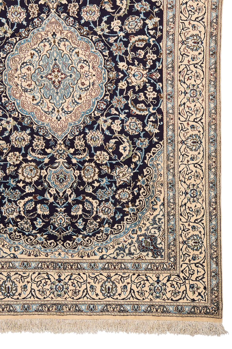 Detalle del medallón central y las flores simétricas en colores azul celeste, marrón y marfil, resaltando sobre el fondo azul marino.