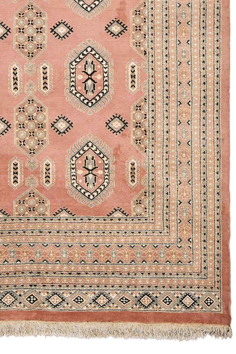 Detalle de la esquina inferior derecha de la alfombra, mostrando los bordes decorativos y flecos.