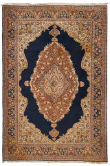 Vista frontal completa de una alfombra persa con fondo azul marino, medallón central floral y detalles ornamentales en tonos beige, terracota y verde oliva.