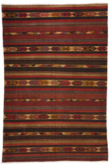 Vista frontal completa de una alfombra kilim con franjas horizontales en tonos tierra y motivos geométricos tradicionales.