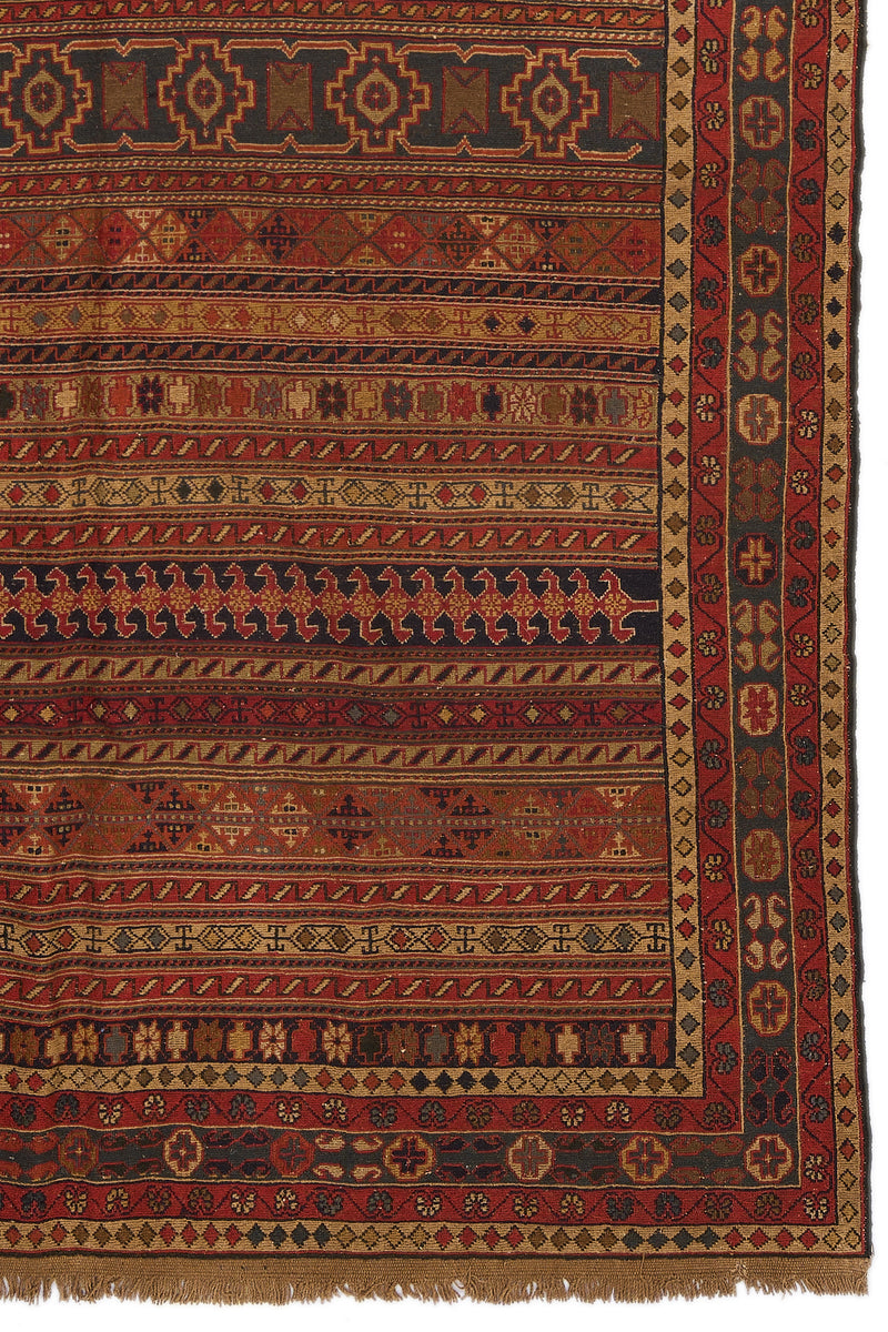 Detalle del borde lateral derecho de la alfombra con motivos florales y cruces enmarcados.