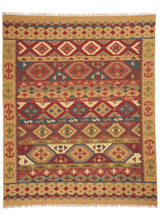 Vista superior completa de una alfombra kilim con patrones geométricos en tonos tierra, rojo, azul y mostaza.