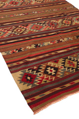 Vista en perspectiva de la alfombra kilim extendida, destacando la textura tejida y los patrones simétricos.