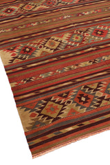 Toma angular de la alfombra mostrando sus franjas decorativas y figuras geométricas tradicionales.