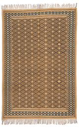Vista completa de una alfombra artesanal de fondo beige con patrones geométricos marrones, enmarcada por una guarda de rombos celeste y negro.