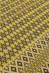 Plano inclinado del patrón central de la alfombra resaltando la secuencia repetida de estrellas negras y cruces geométricas.