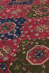 Toma cercana de la superficie de la alfombra mostrando los símbolos cruzados y rosetones en tonos crema, azul y rosa.