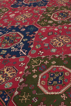 Toma cercana de la superficie de la alfombra mostrando los símbolos cruzados y rosetones en tonos crema, azul y rosa.