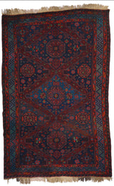 Vista completa de alfombra kilim con diseño geométrico sobre fondo rojo y azul oscuro, destacando motivos octogonales y flores estilizadas.