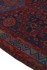 Vista angular de la alfombra kilim con énfasis en el contraste entre figuras florales y líneas cruzadas sobre fondo burdeos.