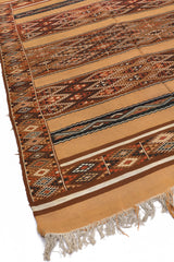 Vista diagonal izquierda que muestra los colores cálidos y patrones entrelazados de la alfombra kilim artesanal.