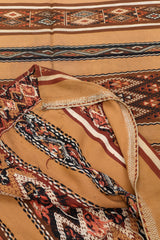Parte posterior de la alfombra kilim doblada, revelando el tejido y los hilos sueltos del reverso artesanal.
