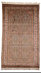Vista completa de alfombra con fondo verde oliva, motivos florales en tonos pastel y bordes ornamentados en marfil, rojo y azul marino.